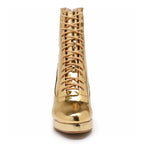 Front view of Bailaquis Aadijay gold shiny vegan leather high-heeled boot, featuring a lace-up design with metallic laces and eyelets, and a sleek glossy finish. It includes memory foam padding for a comfortable yet elegant stride.