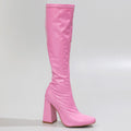 The La Gogo Calf Boot - Pink Wet Look - Street Sole, crafted from stretch vegan patent, is highlighted with its glossy pink finish and striking high block heel against a plain backdrop.